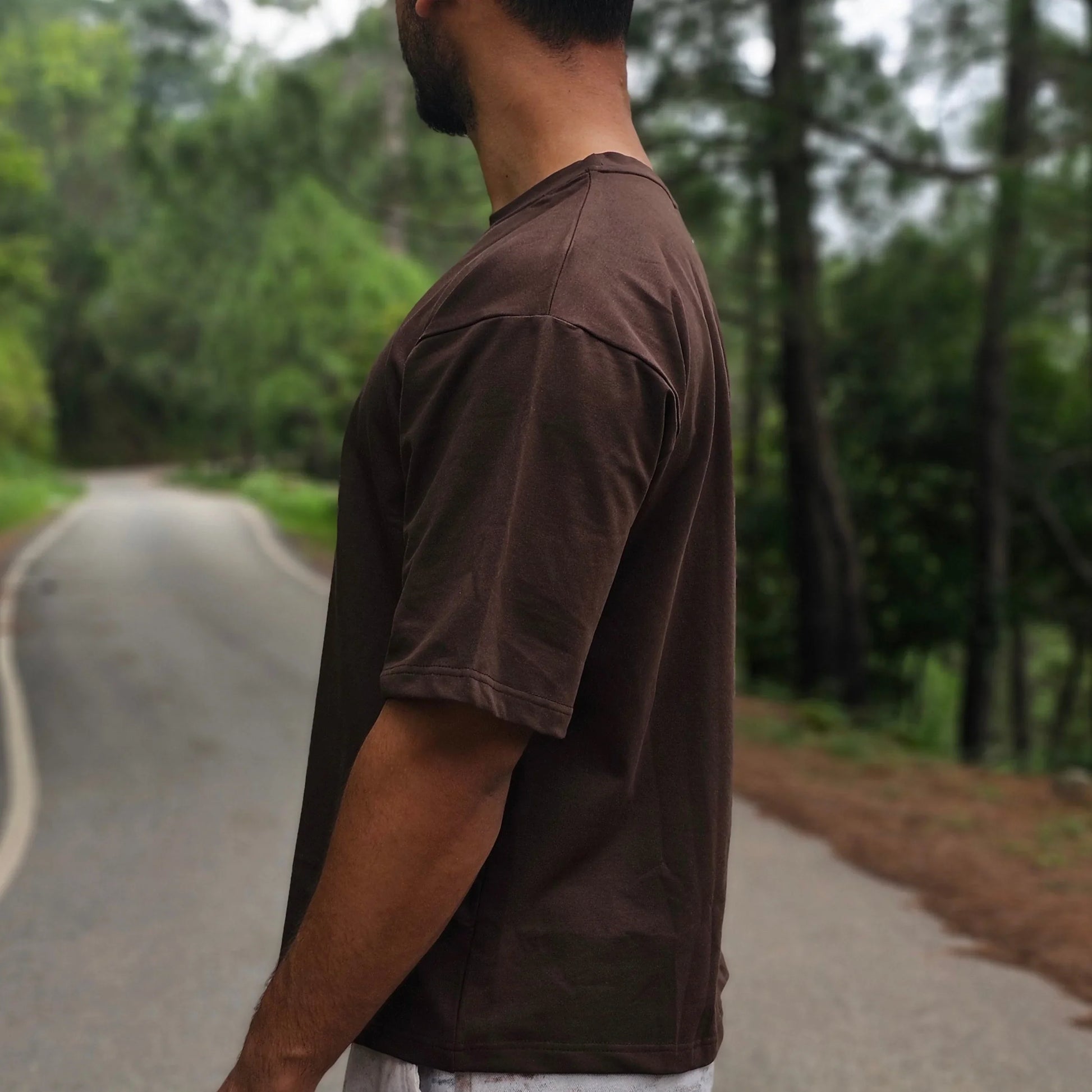 Person standing outdoors with trees in the background