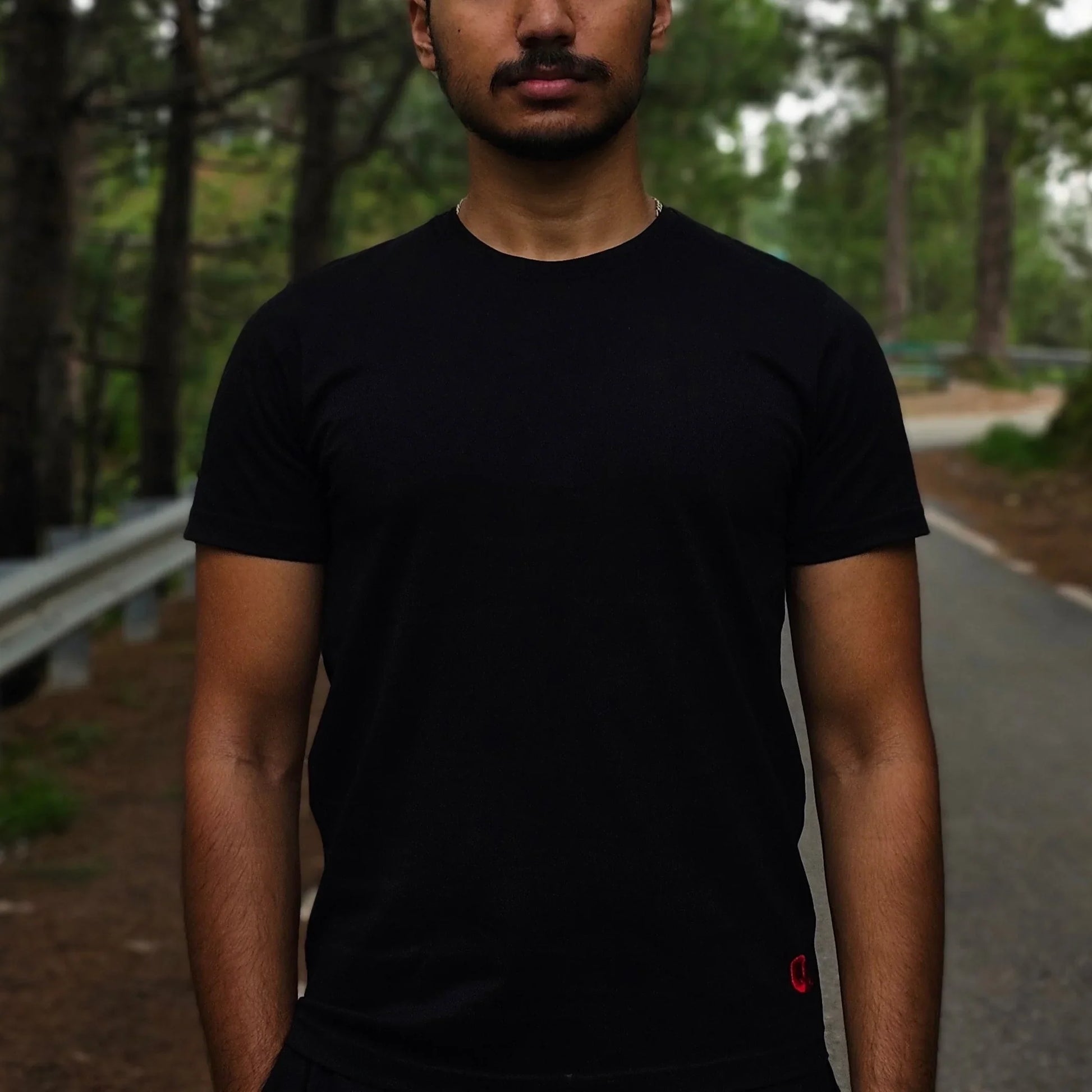 Man standing on a road with trees in the background