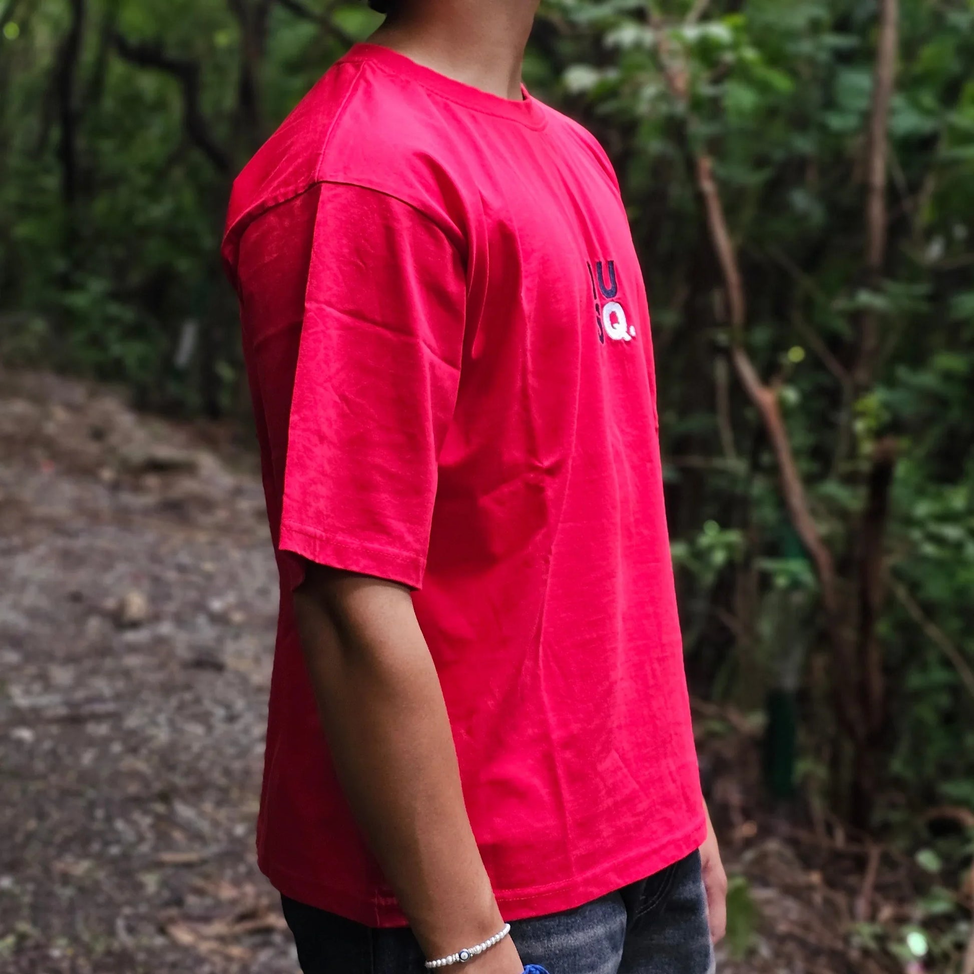 Person wearing a red jacket standing in a forest