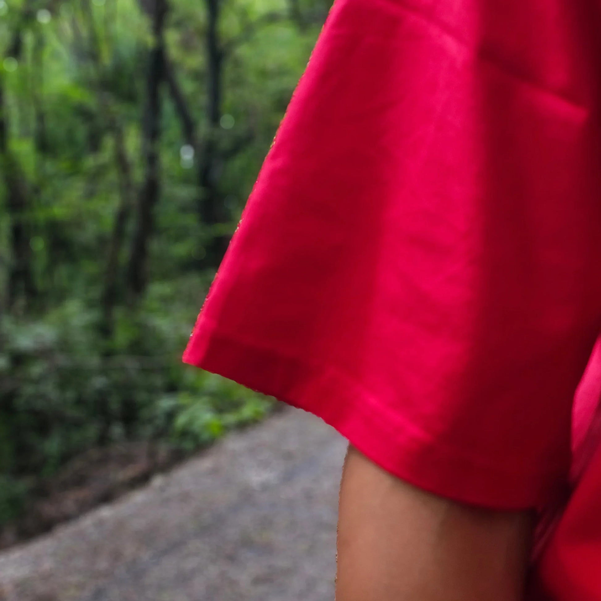 Red fabric draped over a person with a blurred natural background
