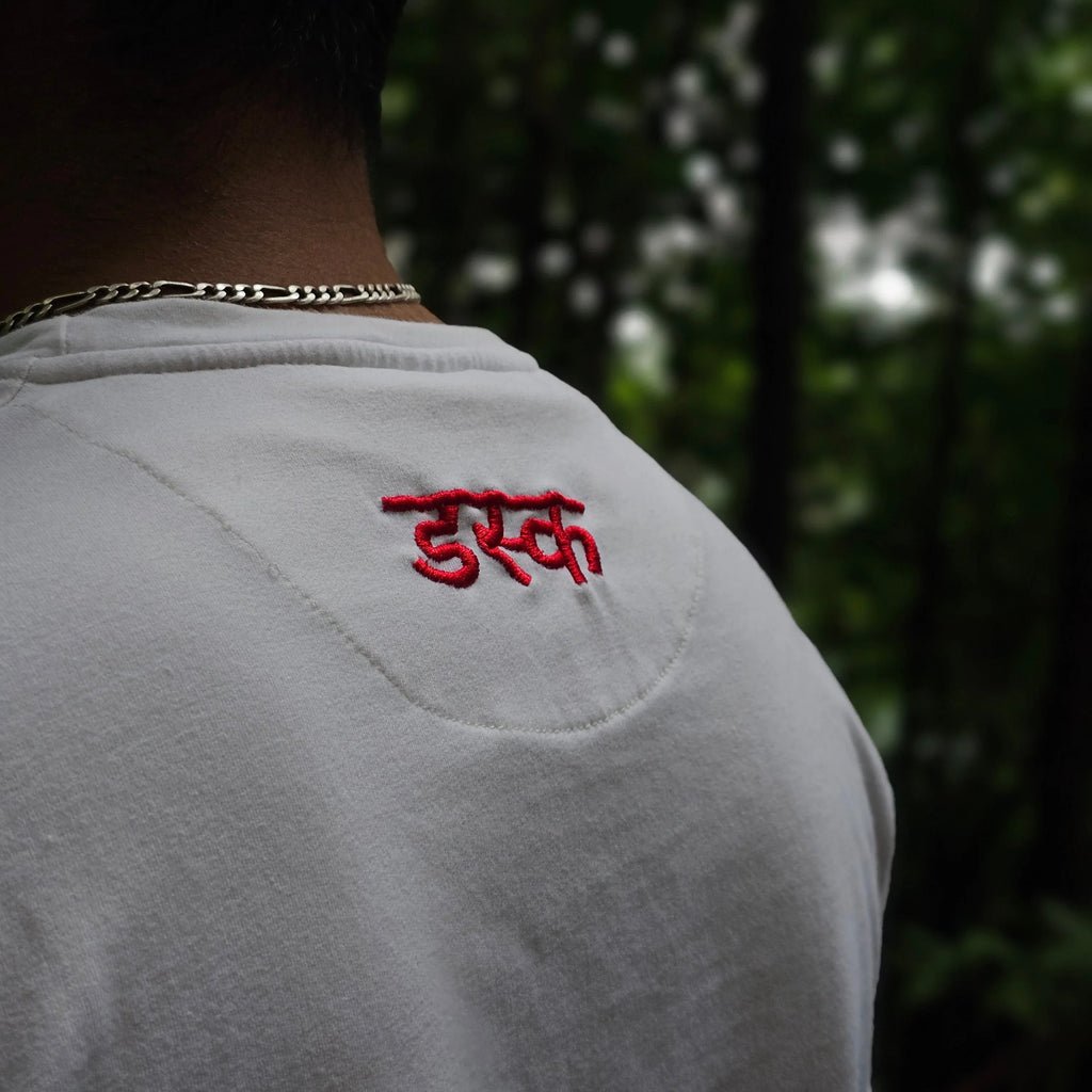 White shirt with red embroidery on a blurred natural background